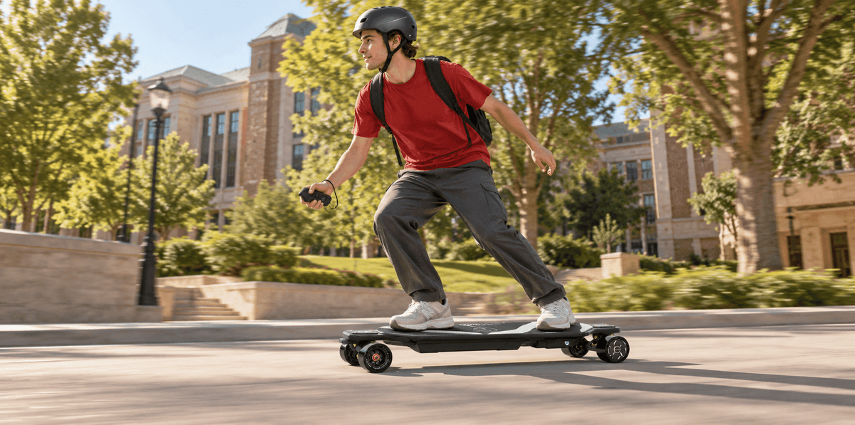 A helmeted rider holds a remote while riding a MAXFIND CYBER MAX hub-motor skateboard along a smooth campus path.